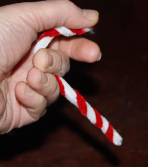 Bend one end of the candy cane ornament to make a curve