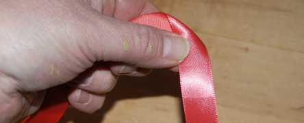 Fold left over ribbon to make rosebud fabric flower.