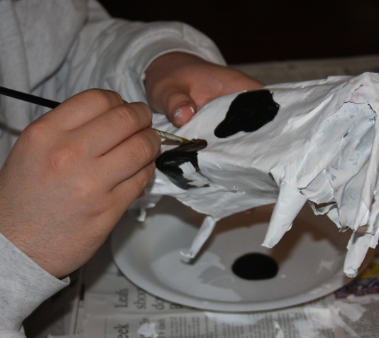 Paint spots of black onto paper mache cow.